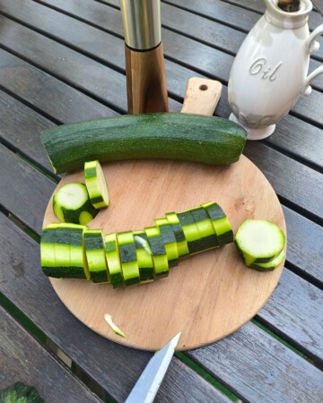 Rezanje tikvica na kolutiće na drvenoj dasci