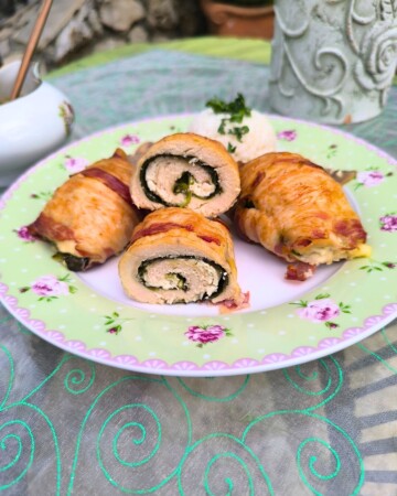 Presjek rolane piletine punjene svježim sirom i špinatom omotane hrskavom pancetom, domaći recept za ukusan ručak.